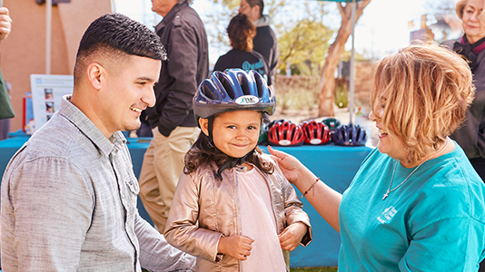 woman fitting bike helmet on child